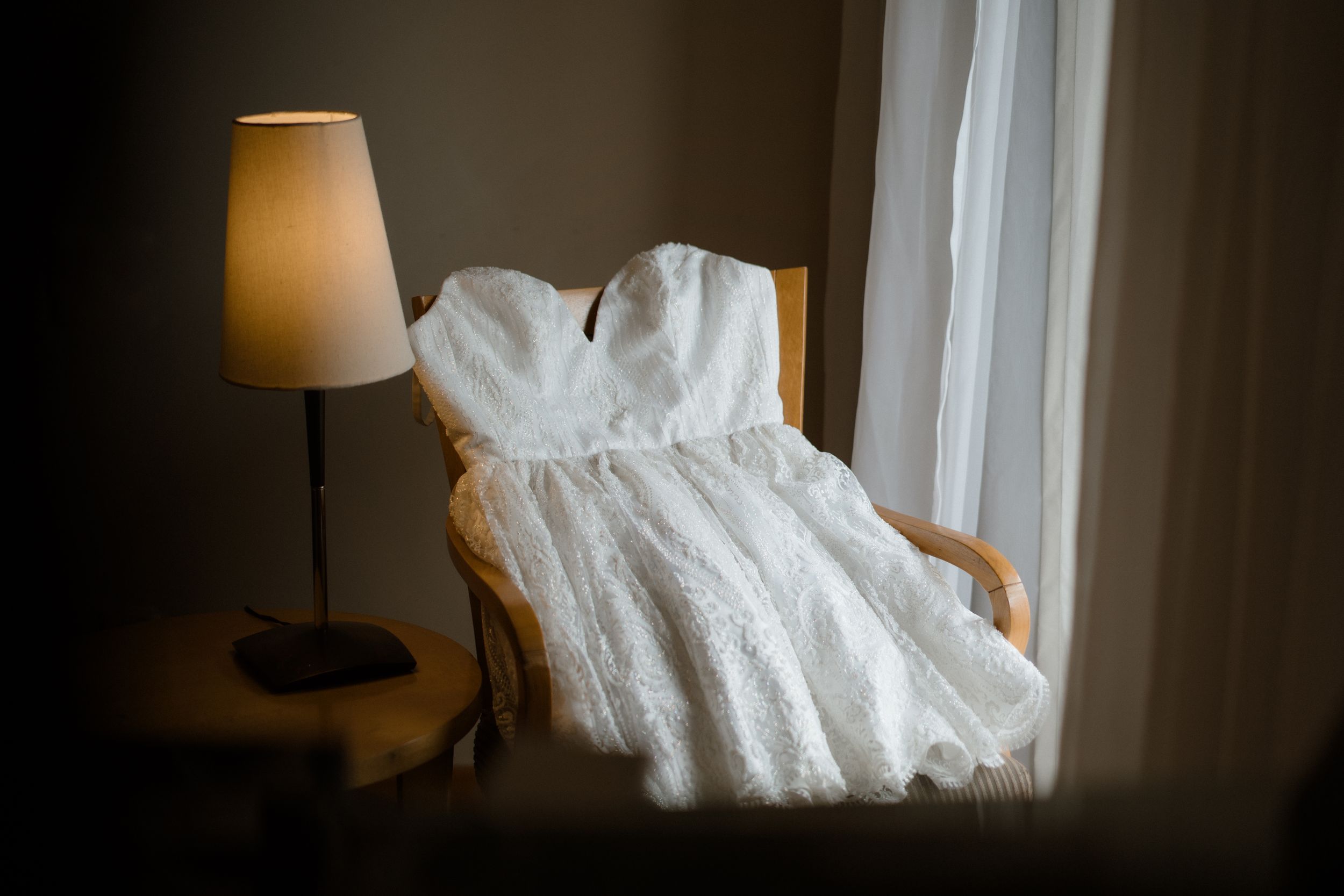 Soft white sheets drape elegantly over a bed in a dimly lit room.