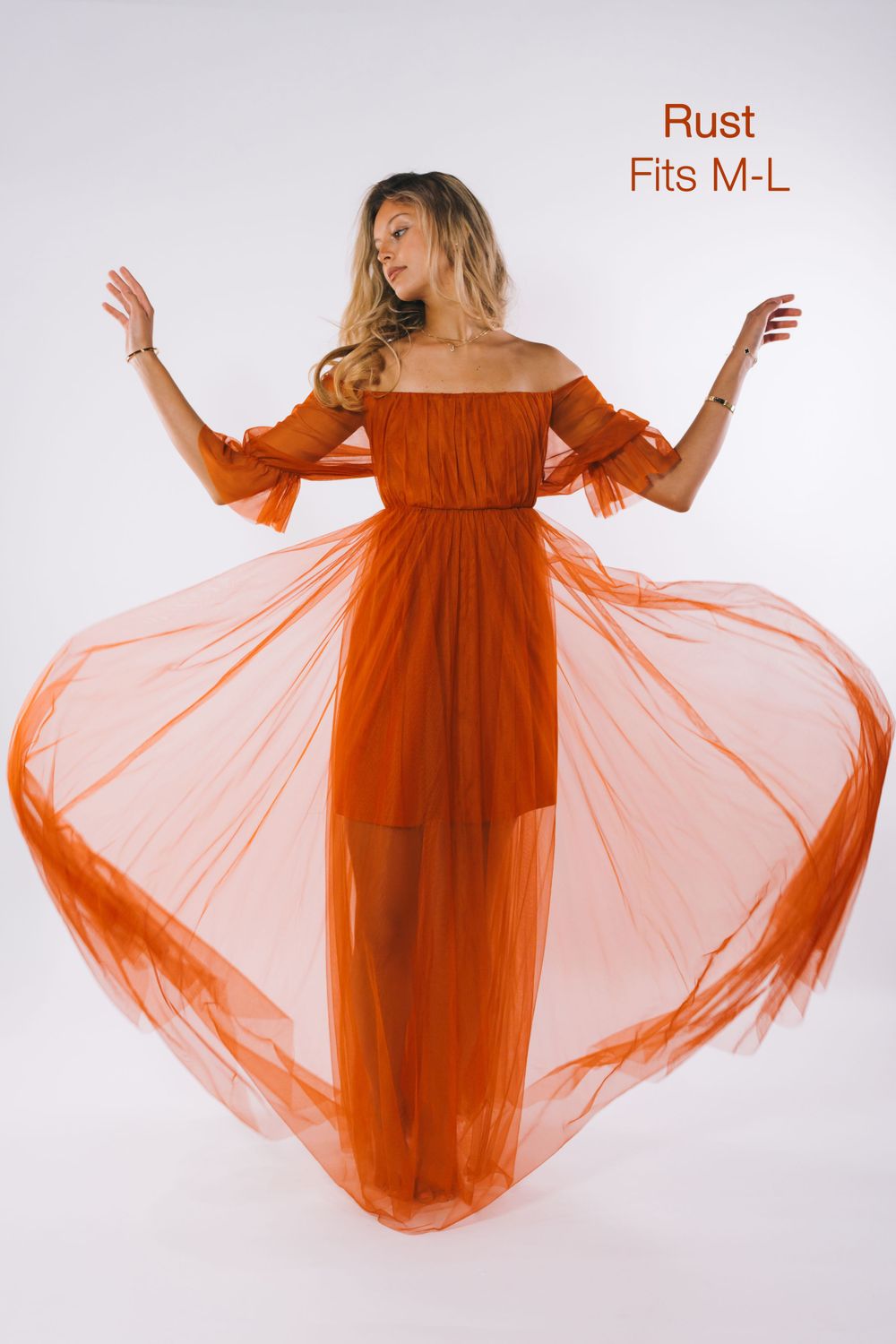 Woman modeling rust orange off-shoulder tulle maxi dress, fits M-L, with flowing skirt.