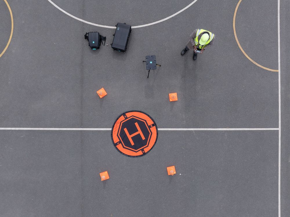 An overhead aerial view of a sports field with orange cones placed in a circular pattern.