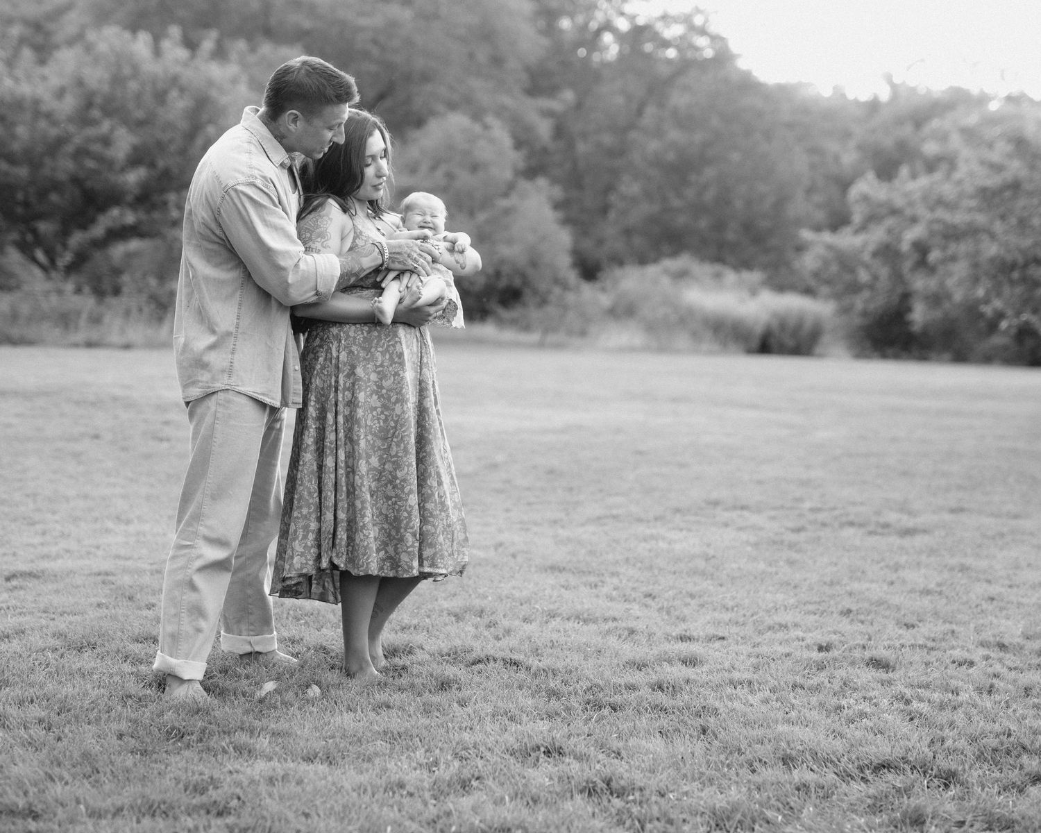 A series of black and white photographs showing a romantic couple embracing in a grassy outdoor setting.