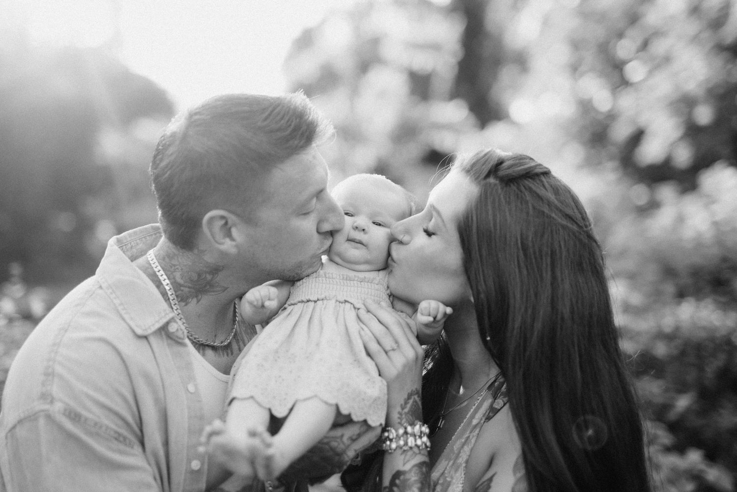 A romantic black and white photo series showing tender moments between a couple sharing kisses in an outdoor setting.