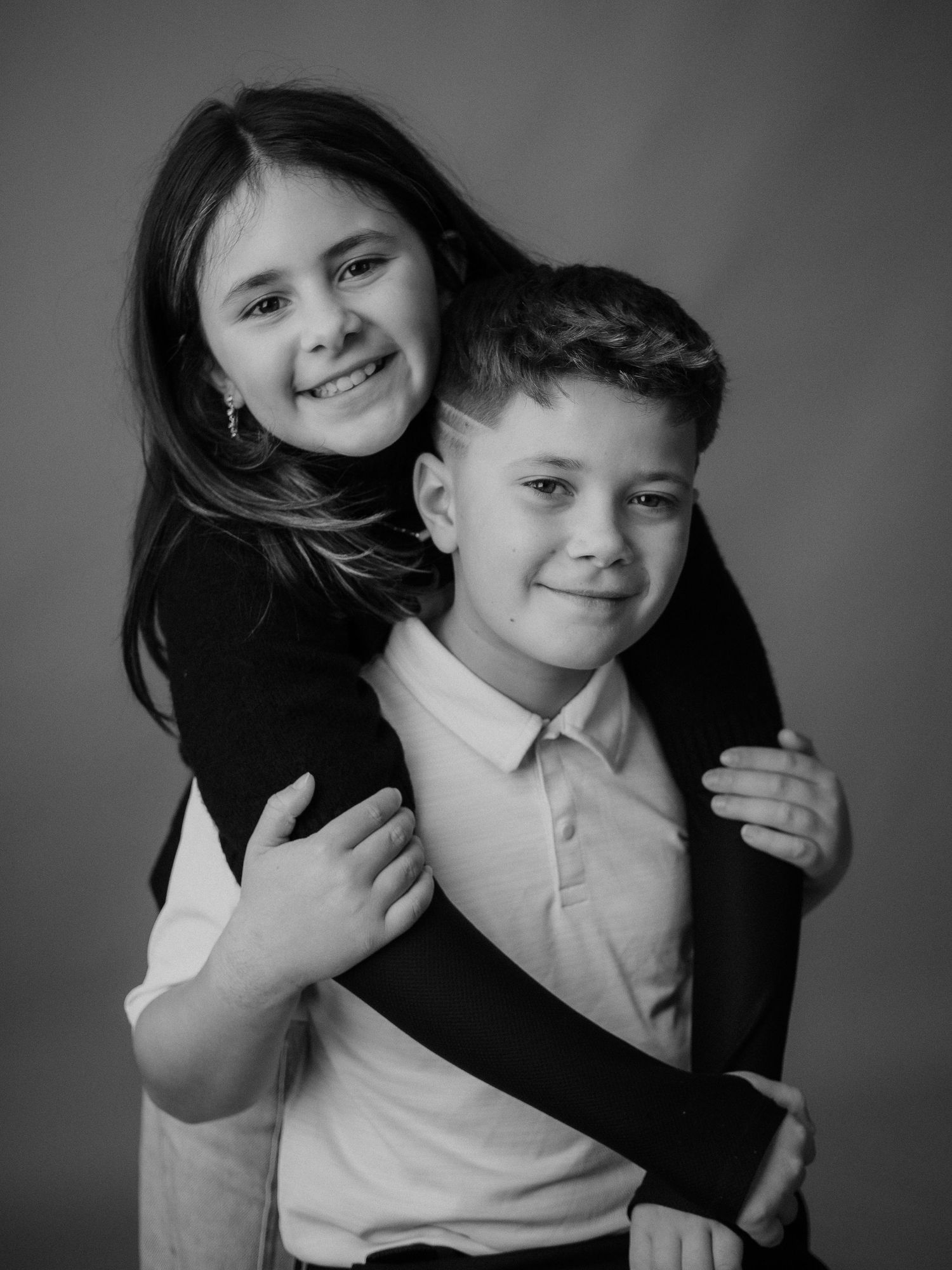 Black and white photo series showing playful interaction between two people hugging and posing together.