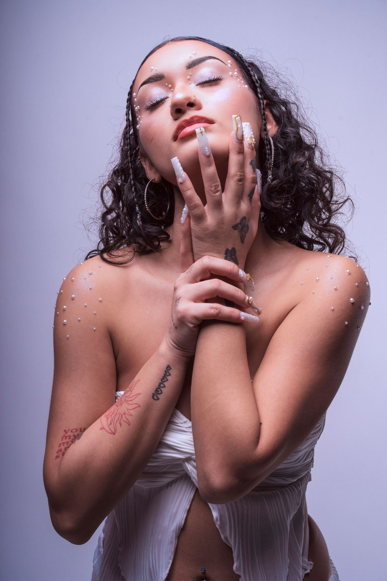 Artistic beauty portrait with glitter makeup and dramatic poses against purple background.