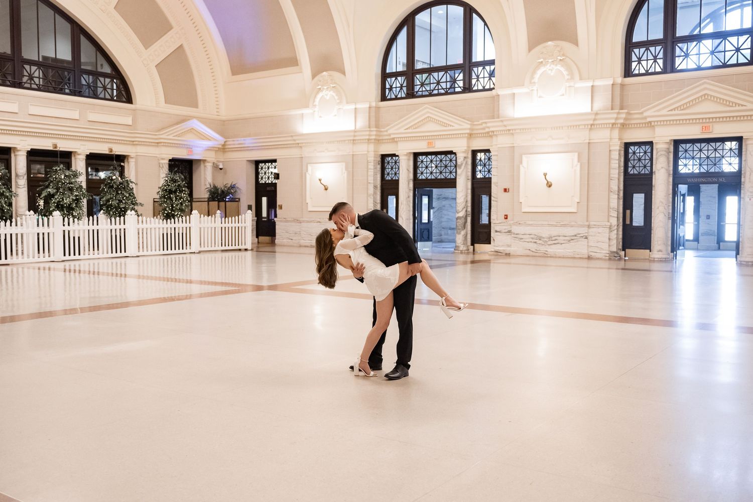Couples dance in an elegant room in a train station with arched windows and ornate architectural details in Massachusetts.