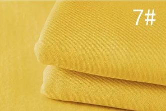 Close up of folded yellow fabric textile material labeled as number 7.