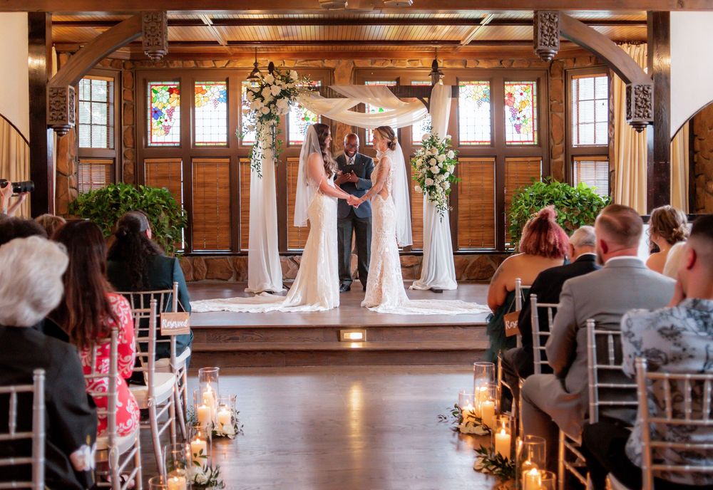 Indoor wedding ceremony venue with wooden beams and natural light streaming through windows.