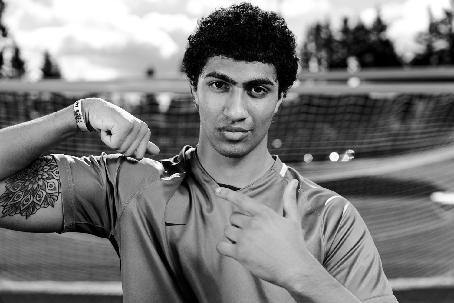 A senior from the Woodinville High School varsity men's soccer team, pointing to his biceps.