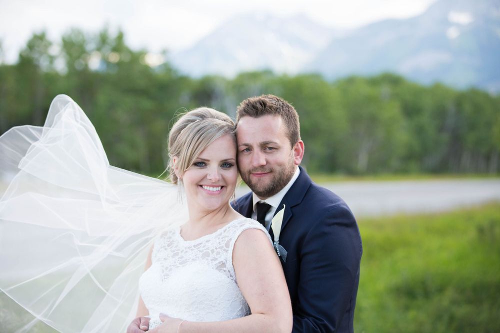 Romantic wedding portraits captured in a natural mountain setting with soft lighting.