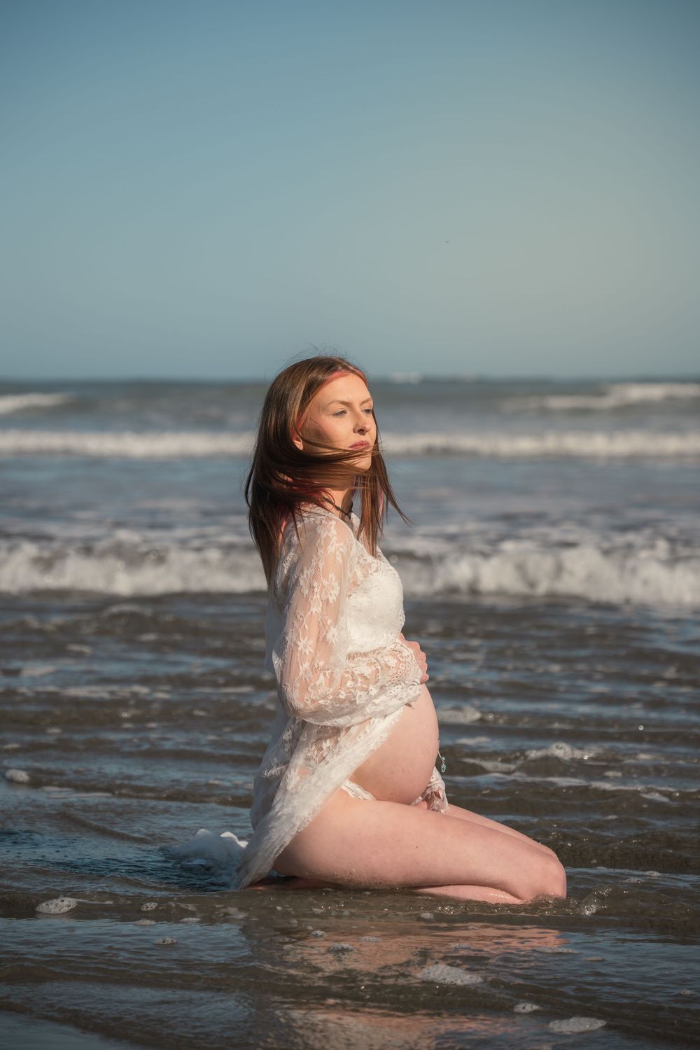 Pregnant woman in lace gown in the water