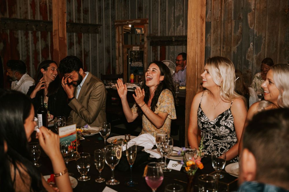 Vancouver Island Wedding photographer photography of wedding guests laughing in barn at Smith Lake farm
