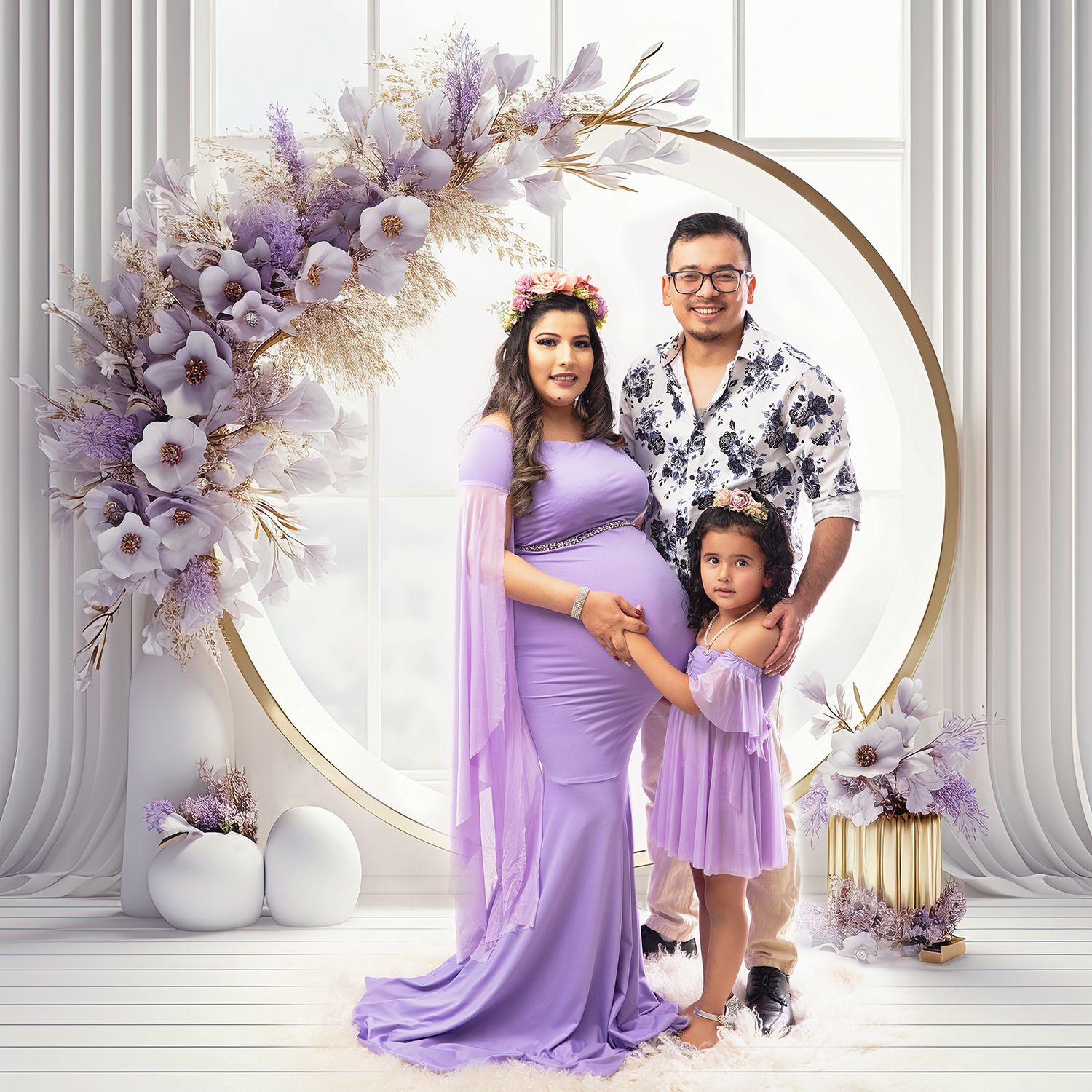 Family maternity portrait in lavender outfits before golden circular arch with floral decor.