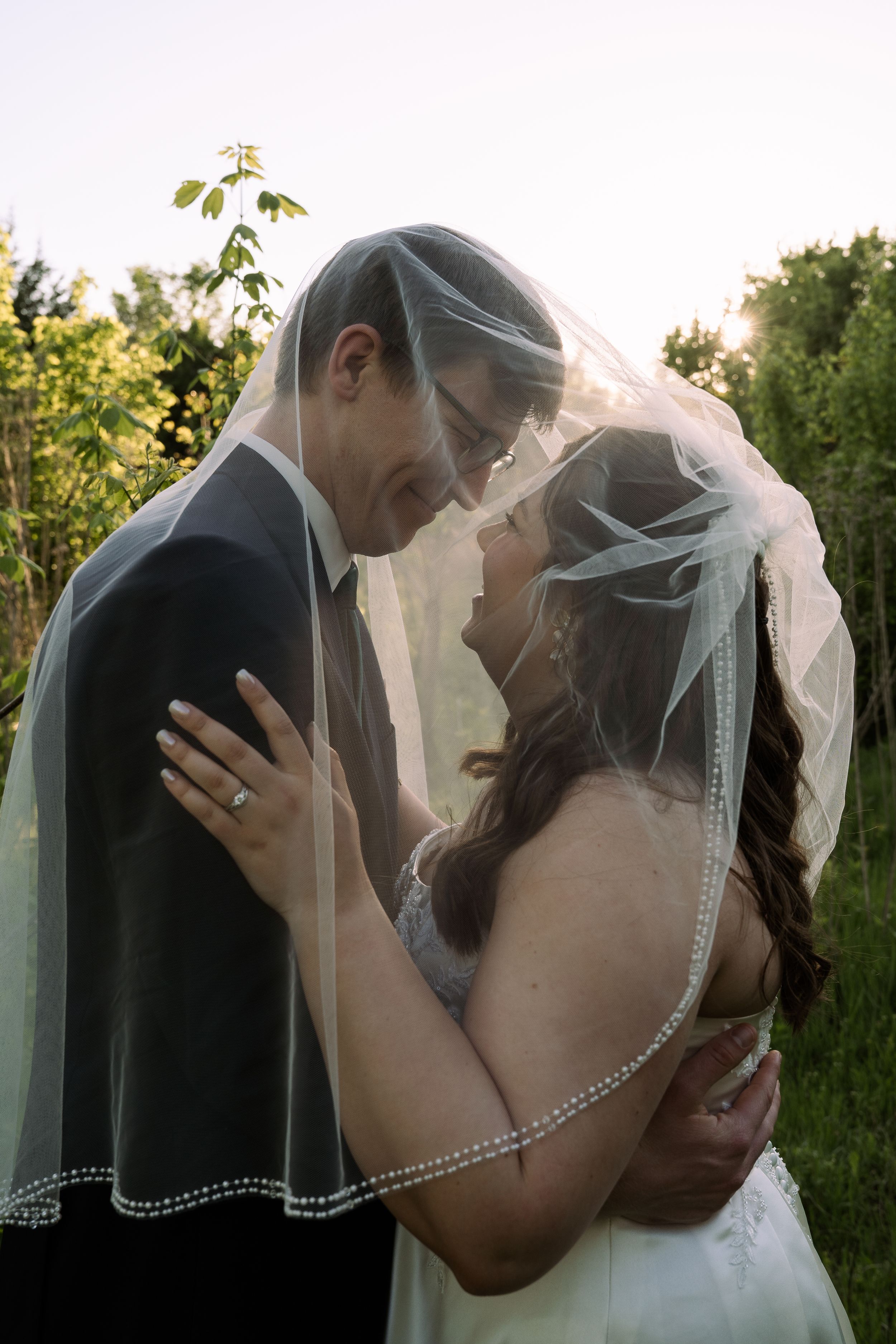 ©AnnaVonRiesenPhotography Bridals Portrait | Color image of a couple smiling at each other.