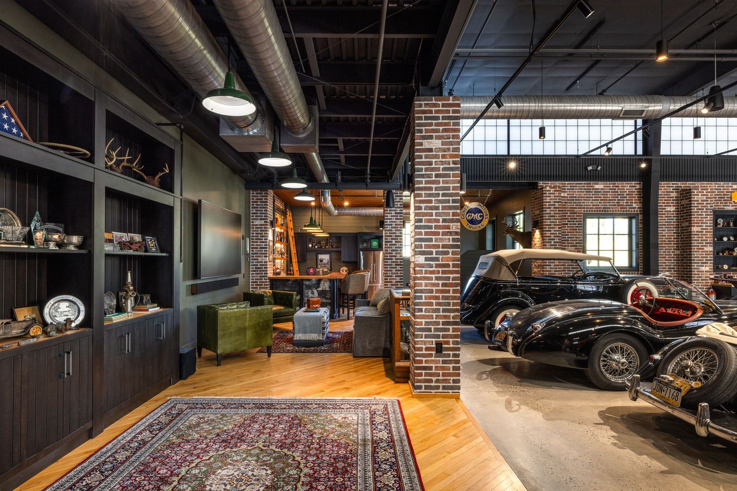 Luxury garage showroom with vintage classic cars, brick pillars, Persian rug, and elegant wood shelving in industrial space.
