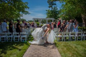 Bride and groom dip on wedding day with guests