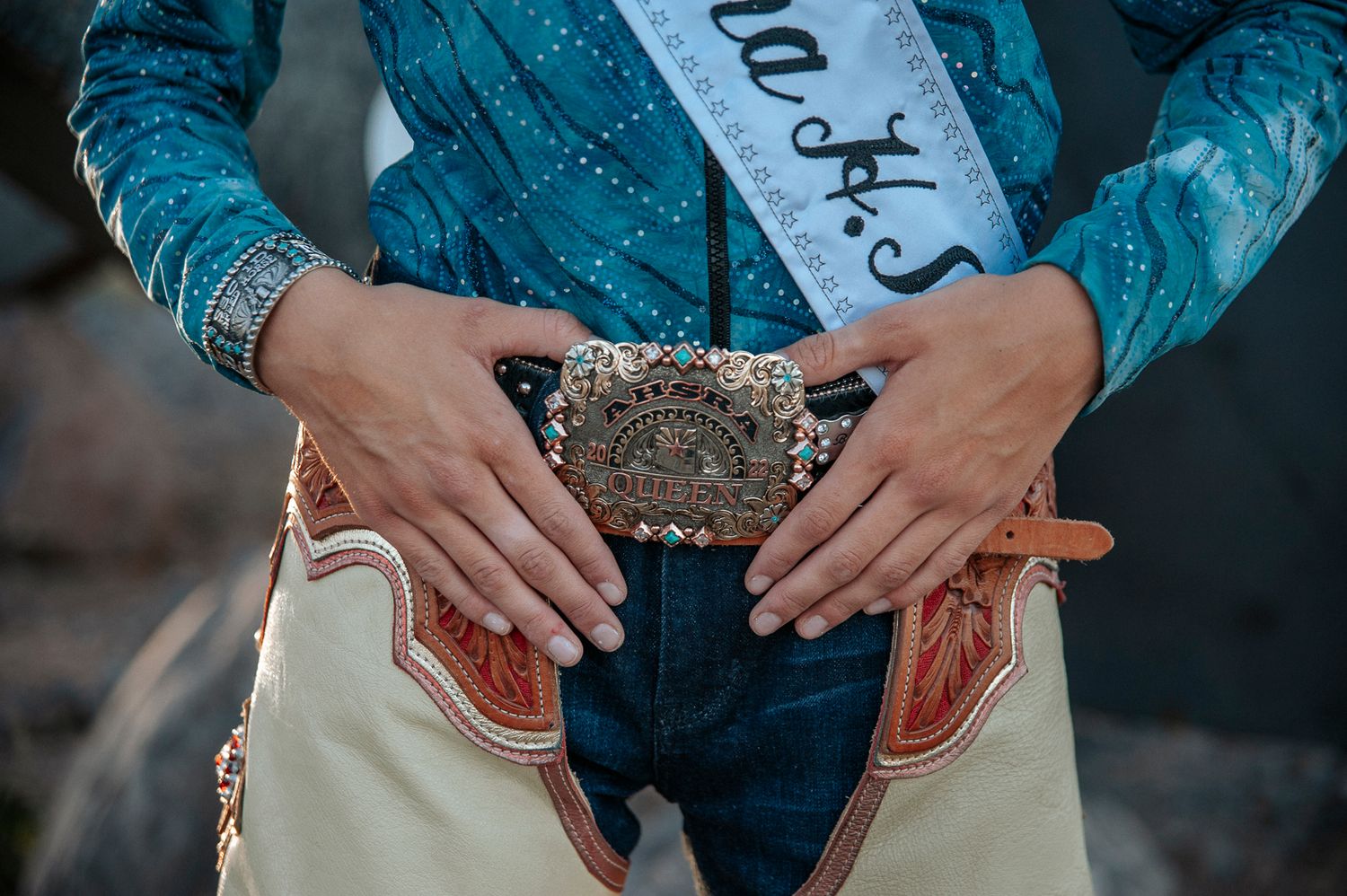 Close-up detail of western-style belt buckle with decorative embellishments.