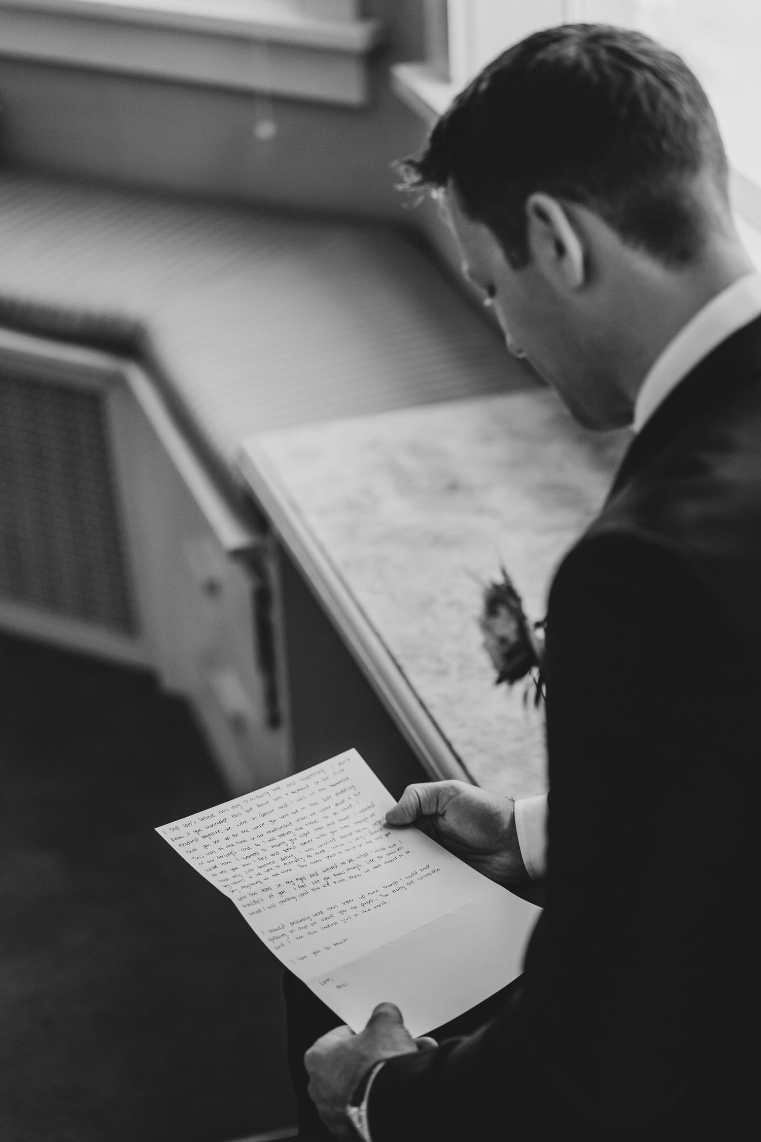Person in formal attire reading handwritten notes or vows.