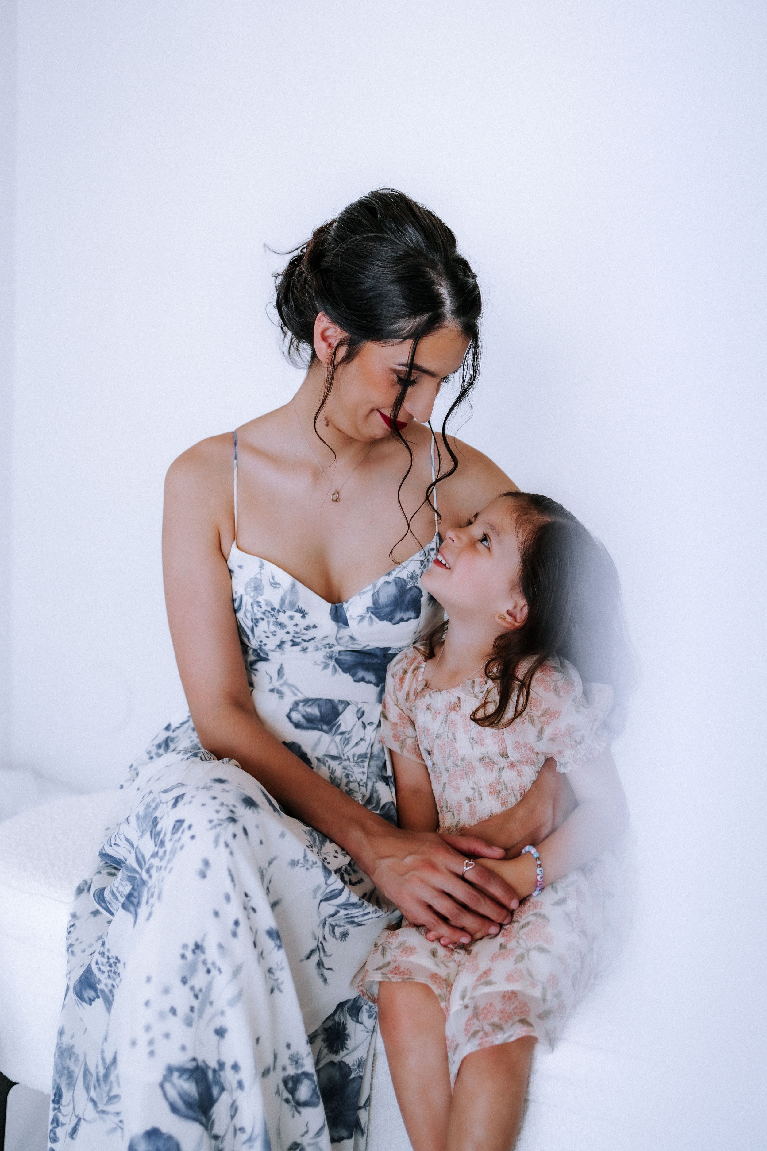 Intimate family portrait session with delicate floral dresses in muted blue tones.