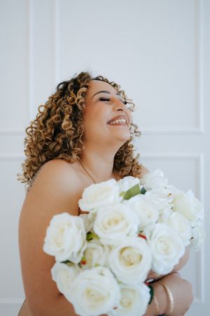 Close-up shots of curly hair with white roses against white paneled background.
