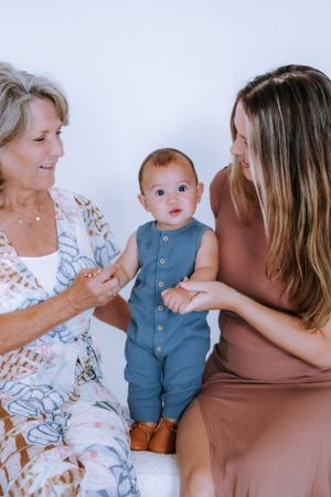 Family portrait session showing tender moments between three generations.