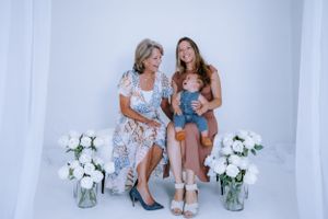 Studio photography session with two people sitting and laughing together.