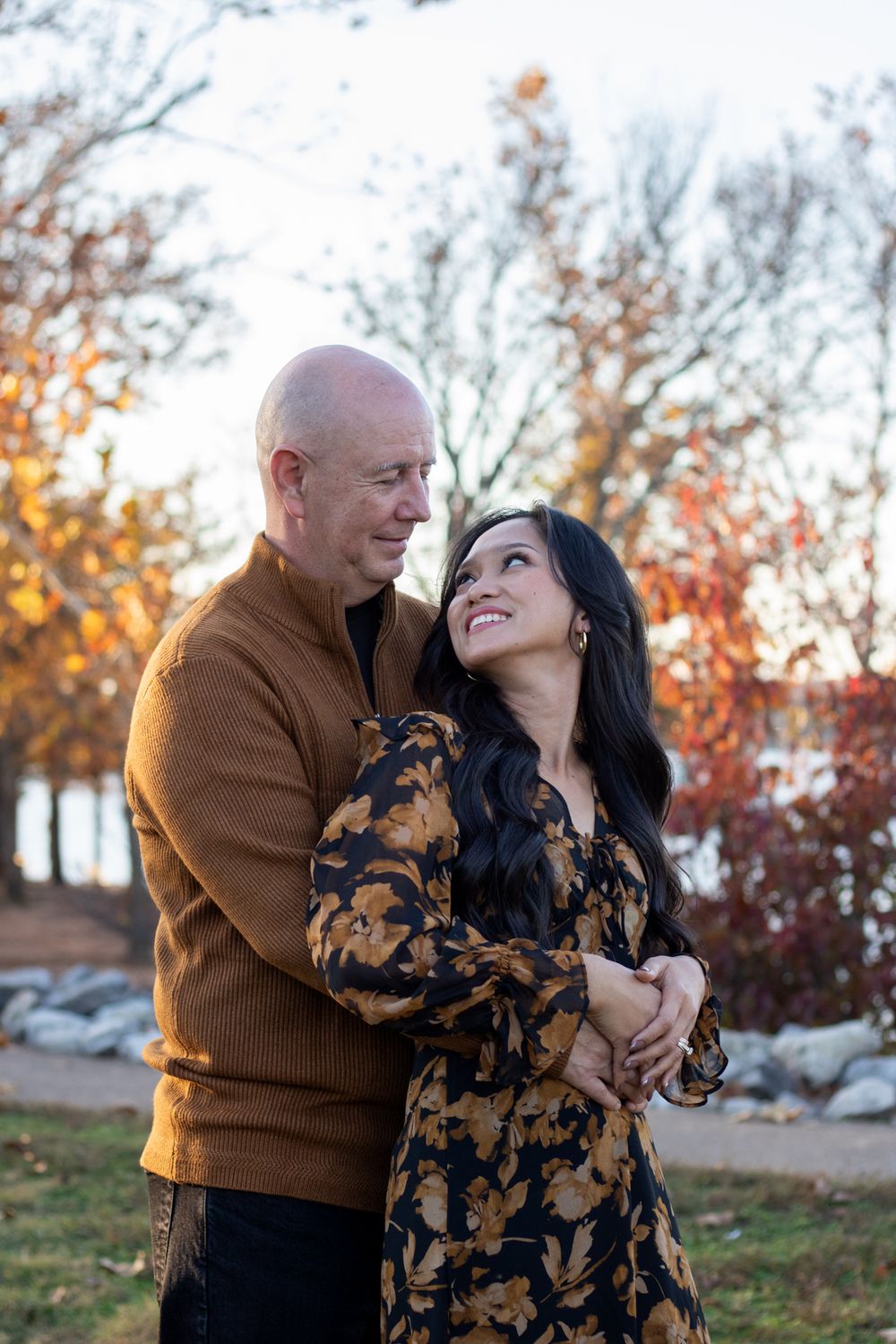 Husband and wife holding each other smiling at each other.