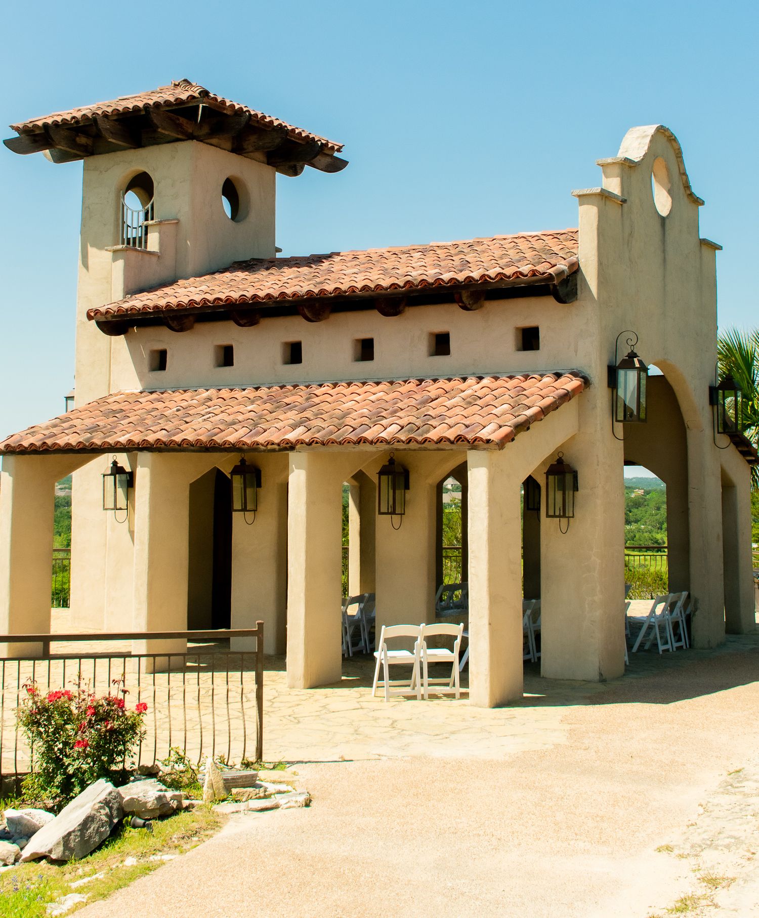 Spanish colonial style church building with terra cotta roof tiles and white stucco walls.