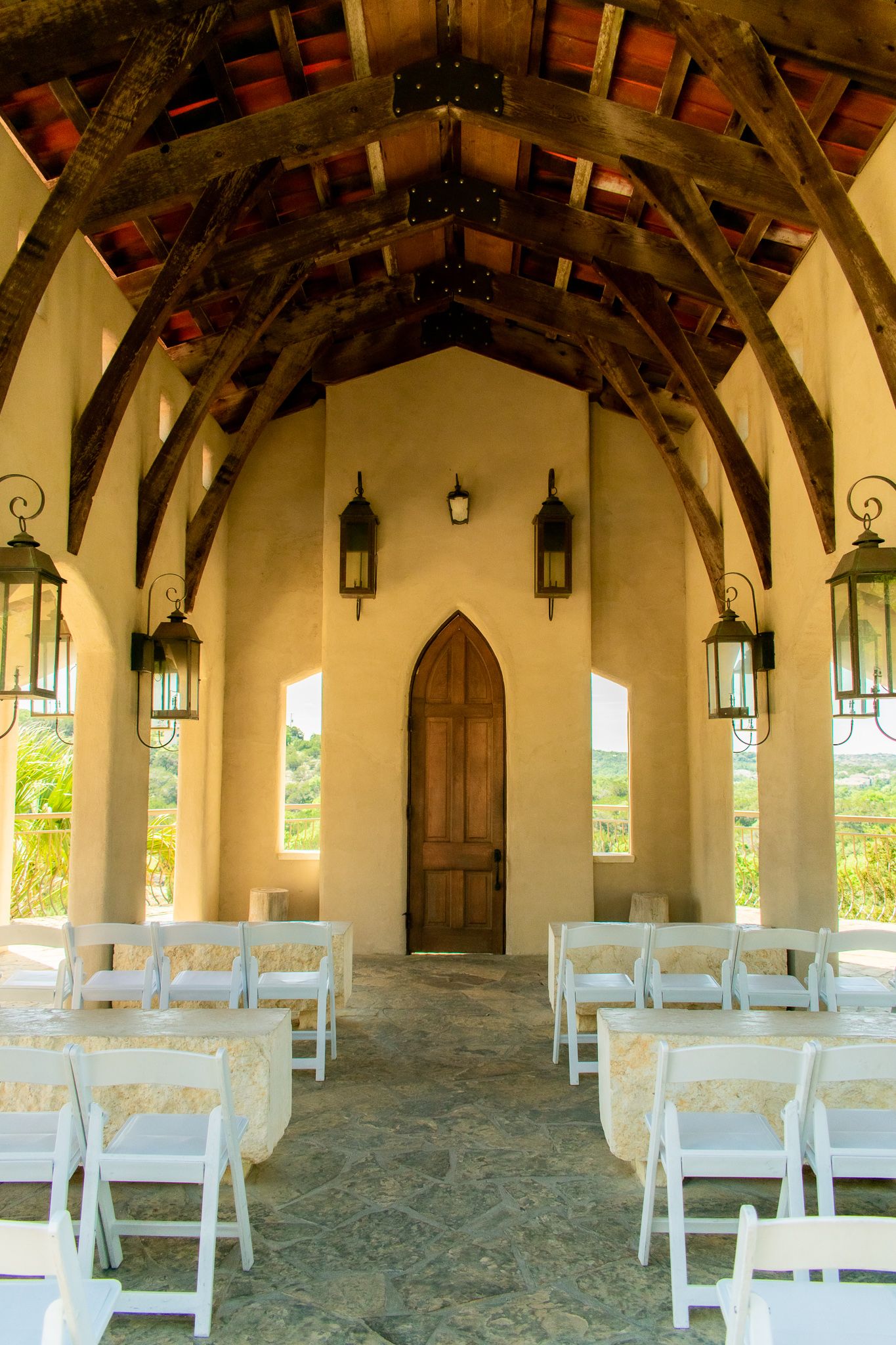 Wedding chapel interior with wooden beams and white chairs lined up for ceremony.