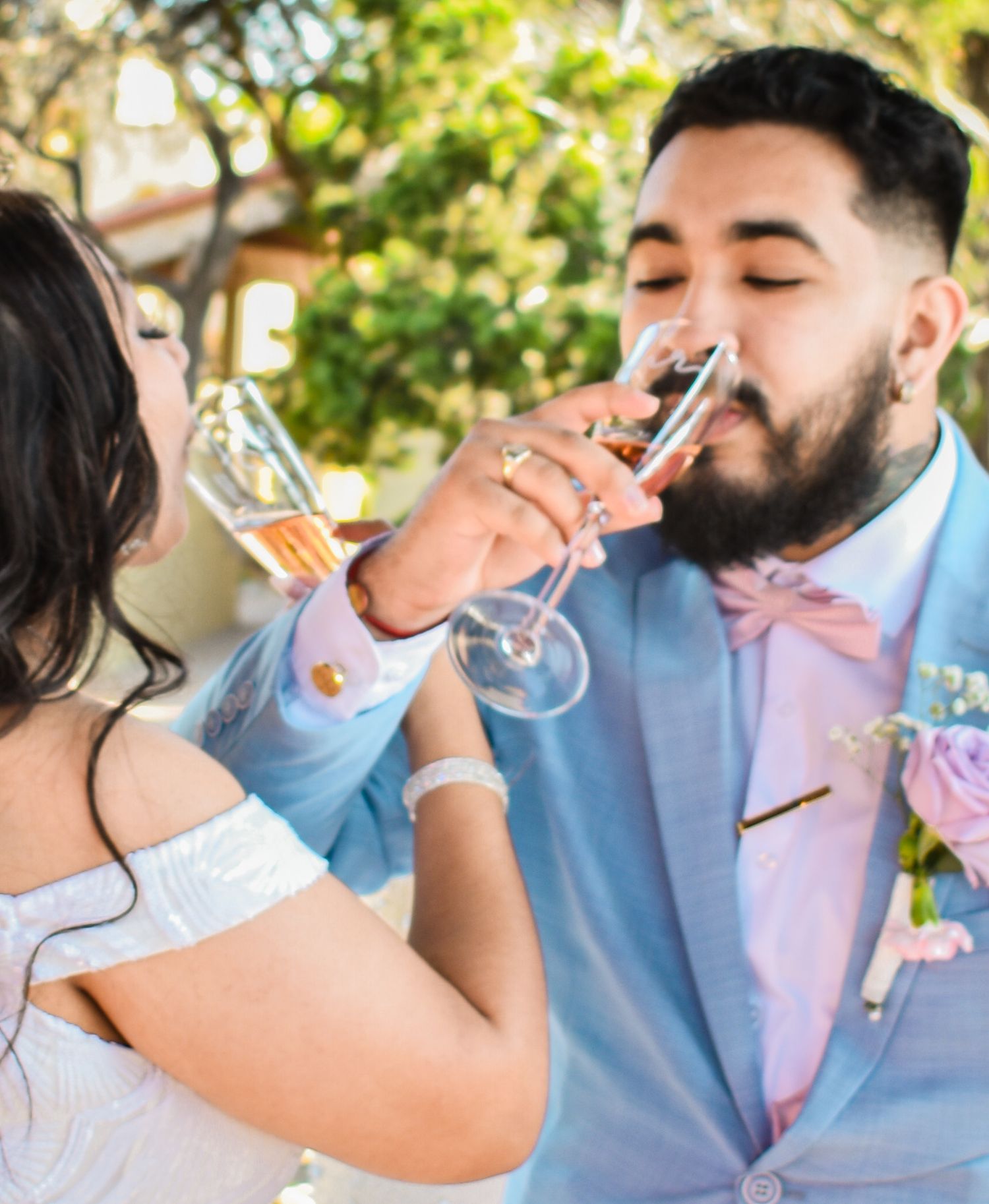 A celebratory moment as a couple drinks champagne at their outdoor wedding reception.