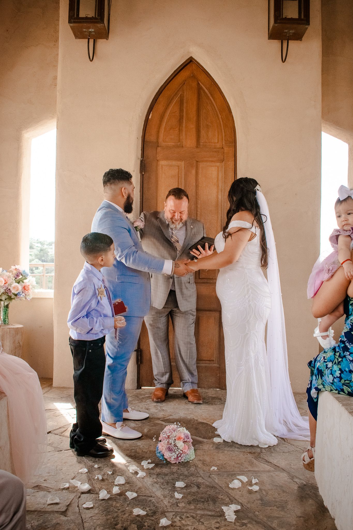 A beautiful outdoor wedding ceremony with stone flooring and gothic architecture details.