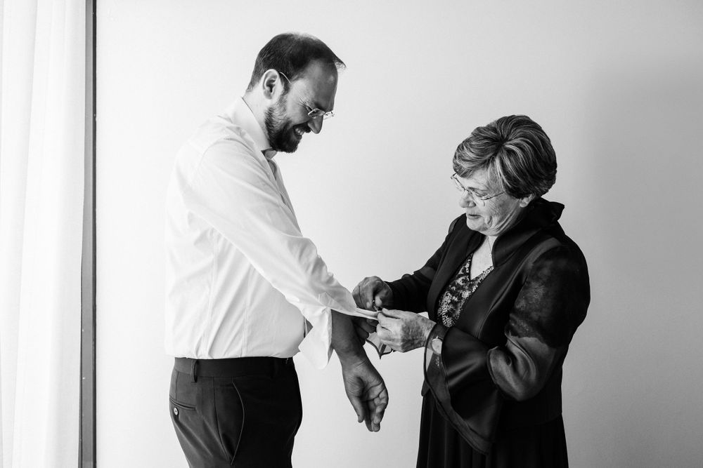 A tender moment between two people during wedding preparations.