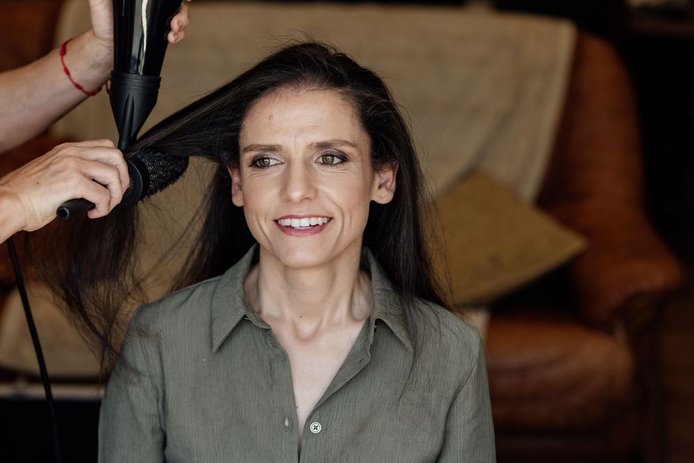 Wedding preparation showing stylist working on bride's hair.
