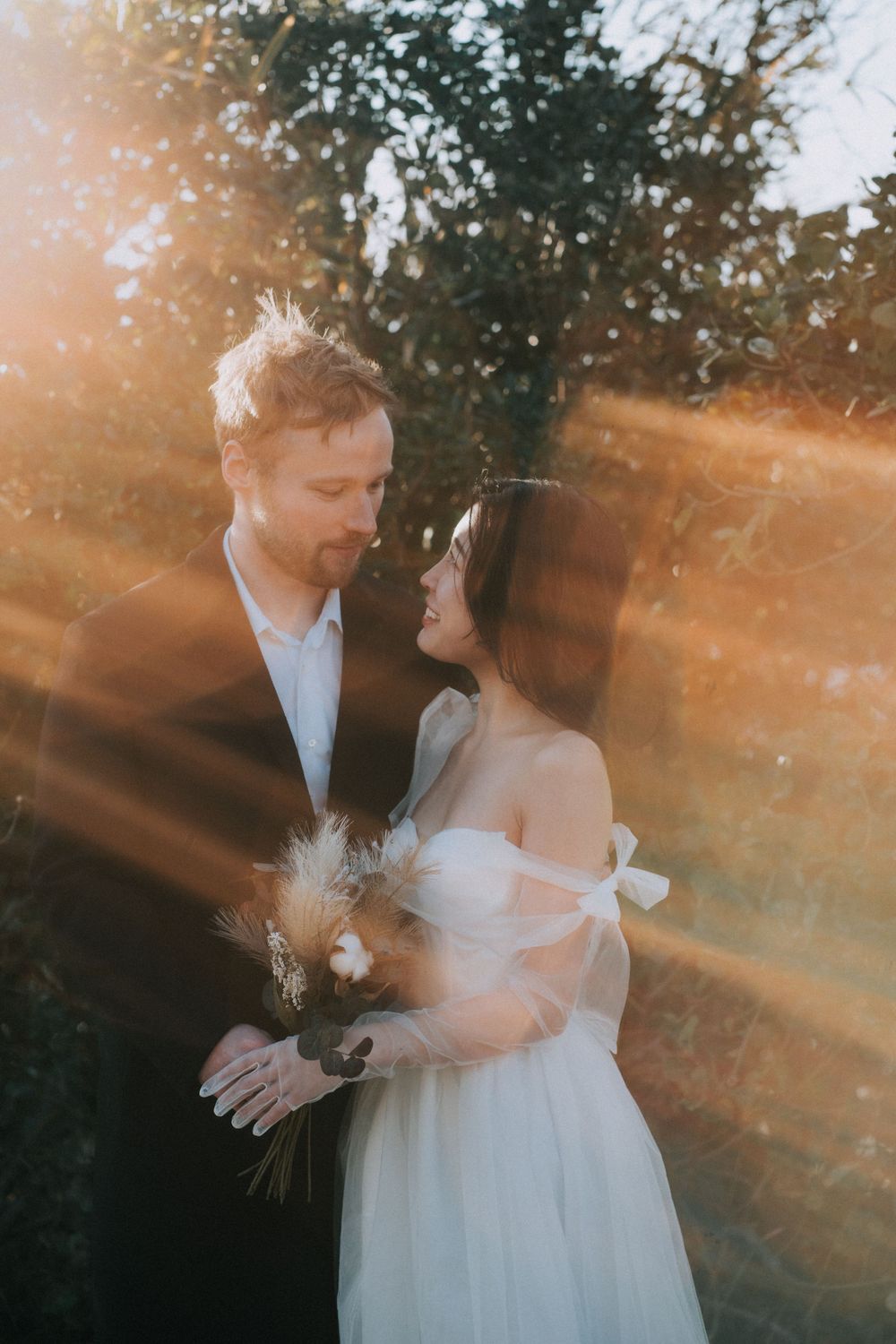 Bride and groom looking at each other in warm sun rays