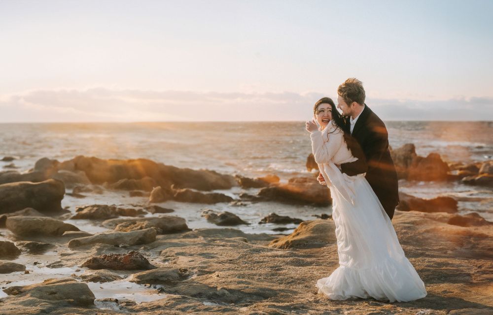 Couple in wedding attire eloping at the beach in Seattle during sunset