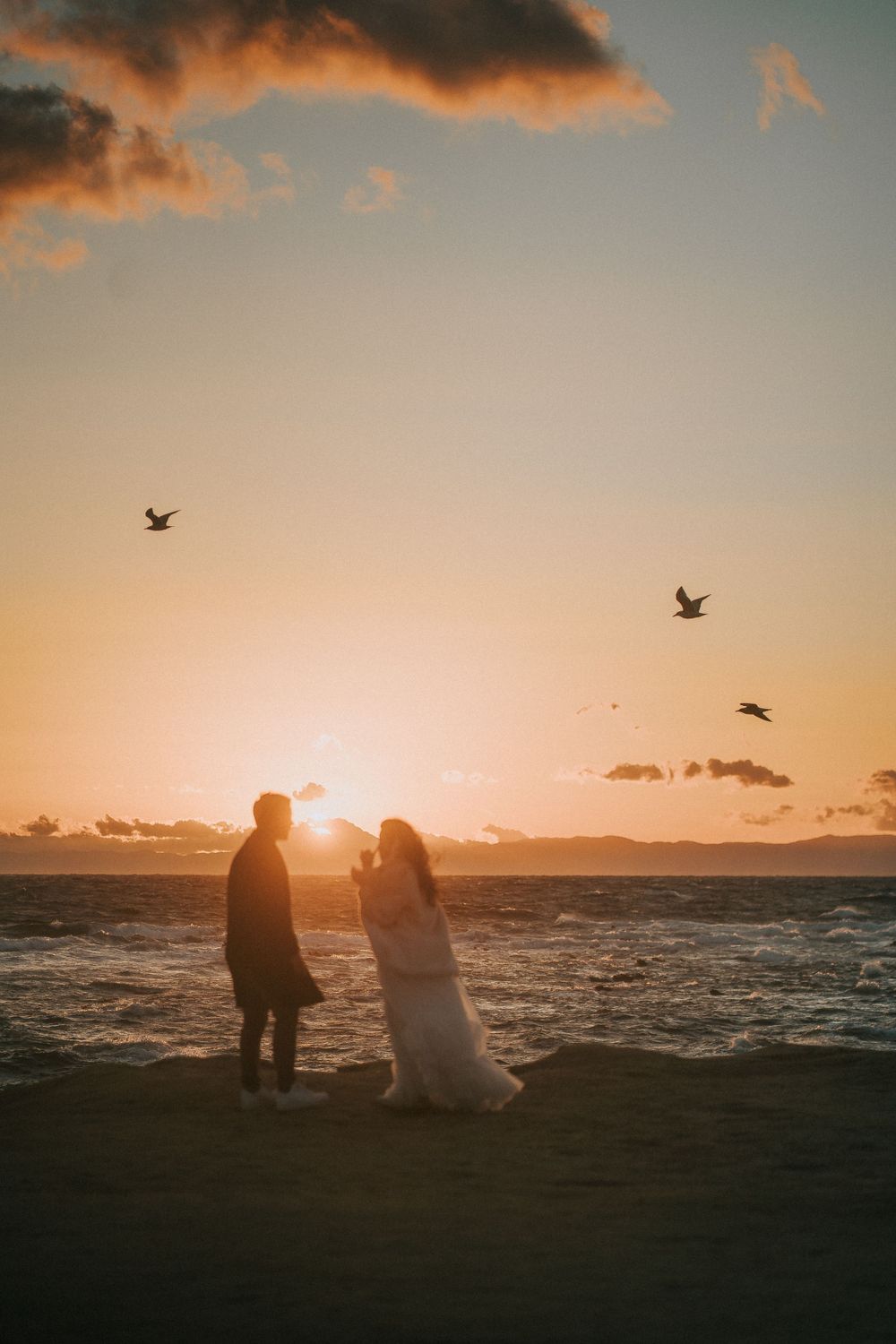 Bride and groom walking on the beach in Seattle during sunset