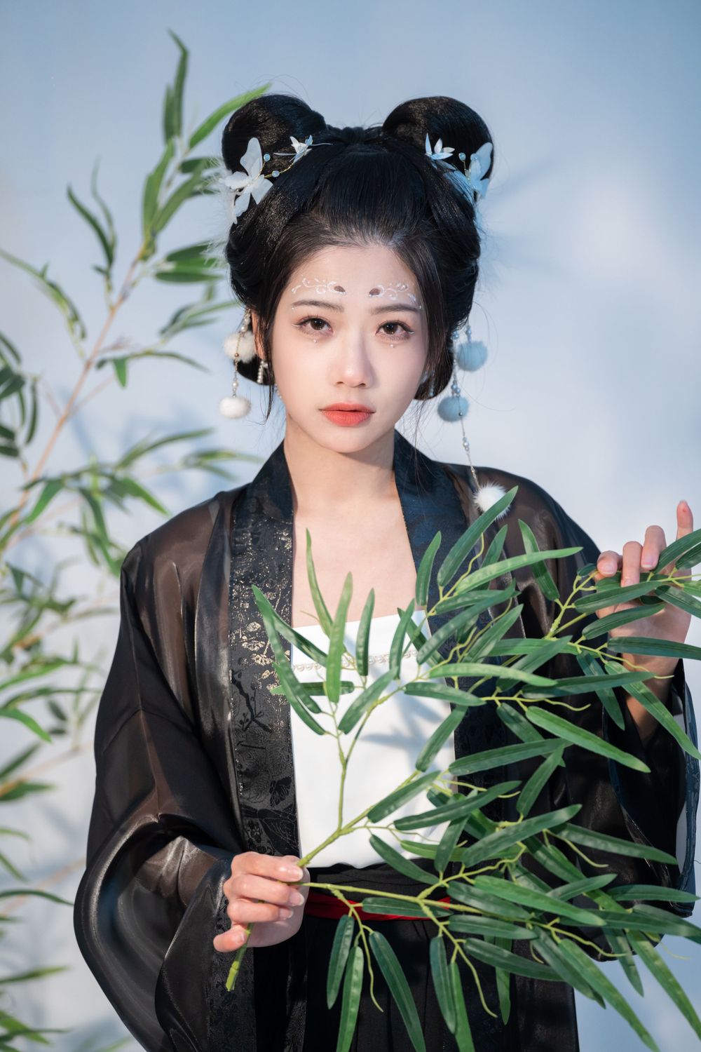 Moody studio portrait of joyful panda cosplay in black & white Hanfu with bamboo, celebrating home, by Imagine Image Studio.