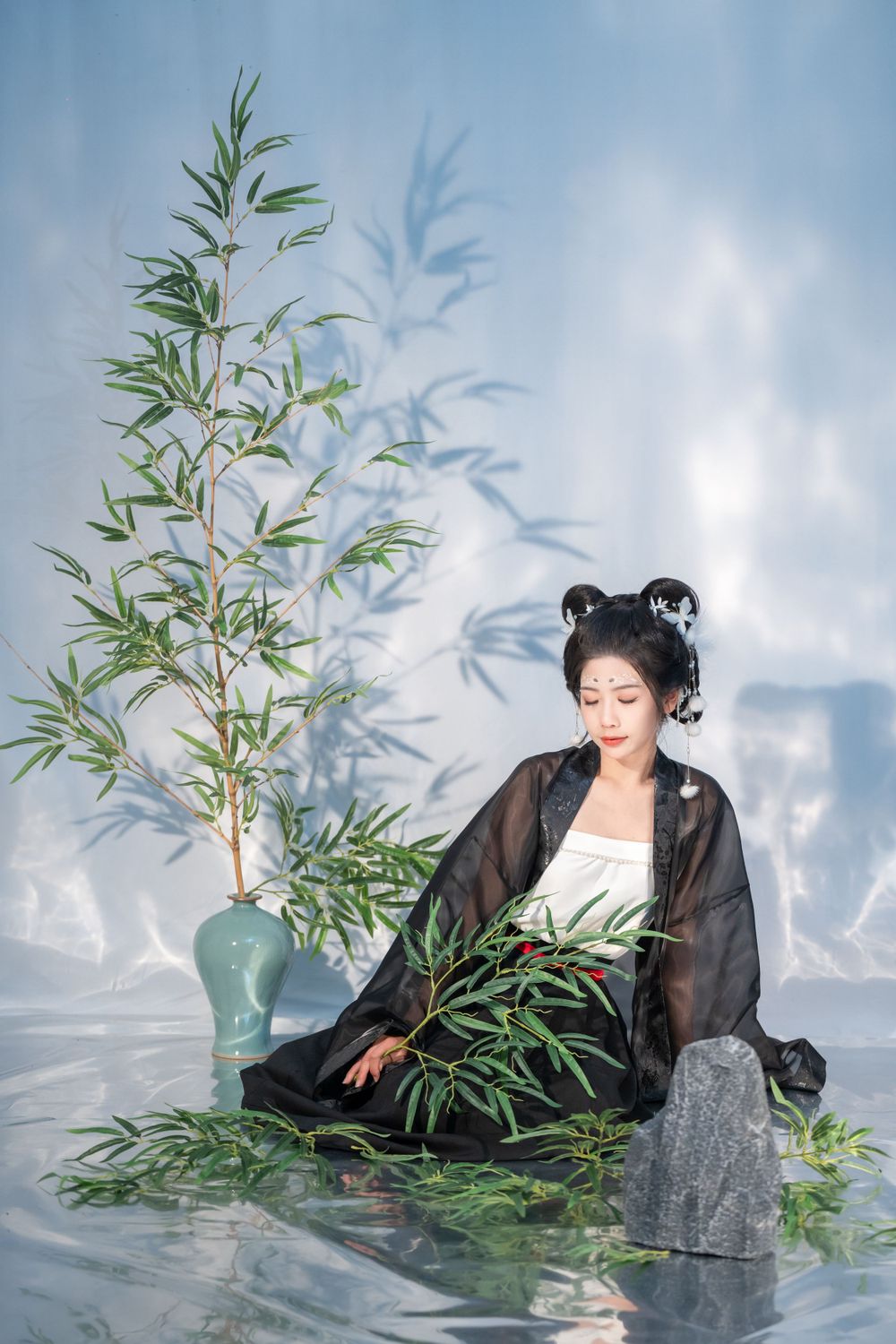 Moody studio portrait of joyful panda cosplay in black & white Hanfu with bamboo, celebrating home, by Imagine Image Studio.