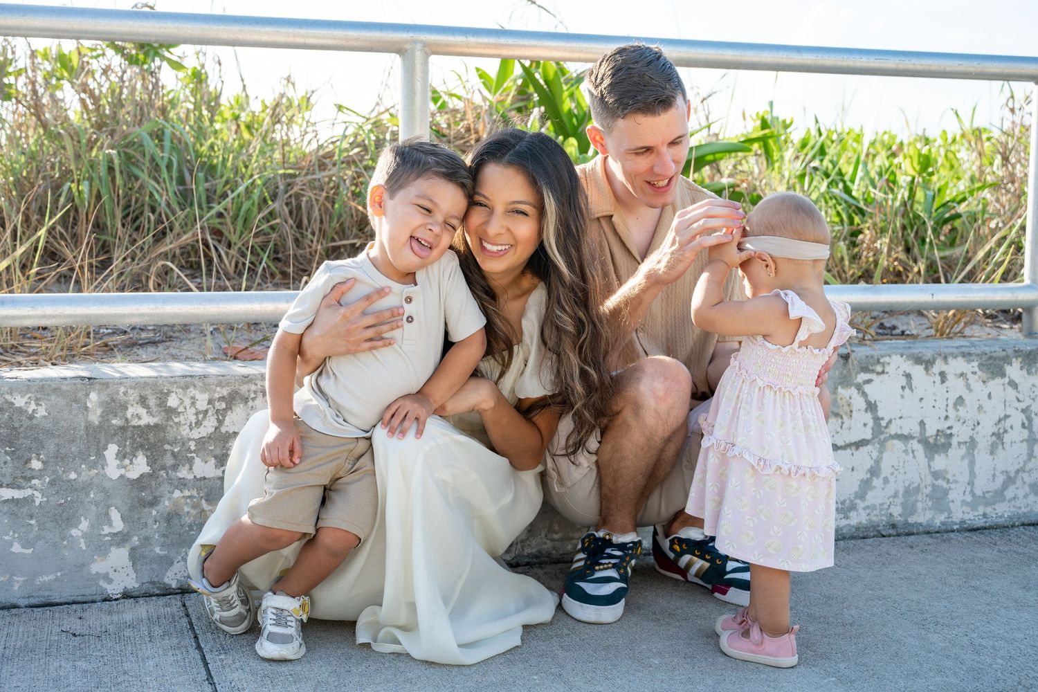 Family sitting together on outdoor patio with ocean view.