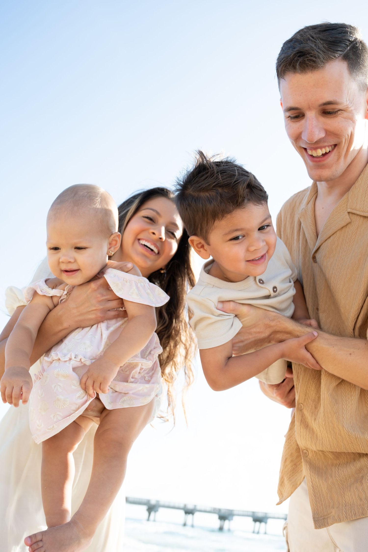 Family enjoying a sunny day outdoors with bright blue sky in the background.
