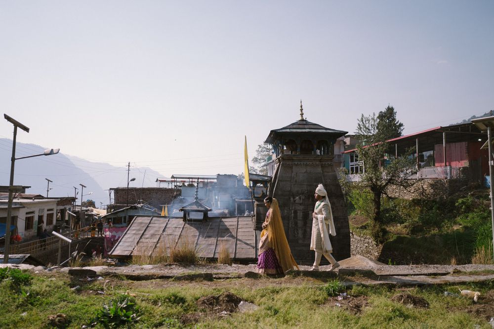 Mountain village landscape with traditional pagoda style tower and mountain backdrop.