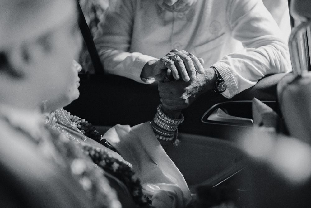 Close-up of hands with traditional Indian wedding bangles and jewelry during ceremony.