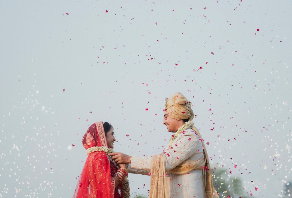 Traditional South Asian wedding ceremony with confetti falling during a joyful moment.