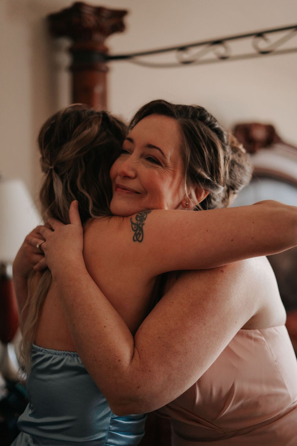 Emotional moment between two people sharing warm embraces during a wedding celebration.