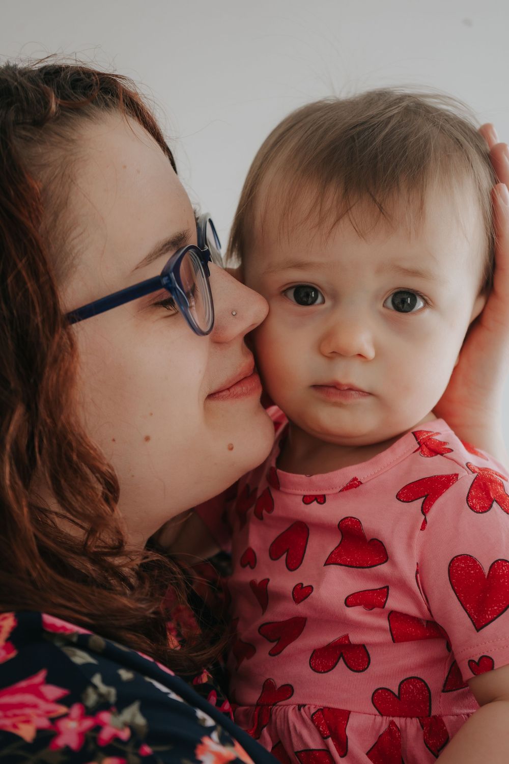 A sweet moment between parent and baby in a heart-patterned outfit.