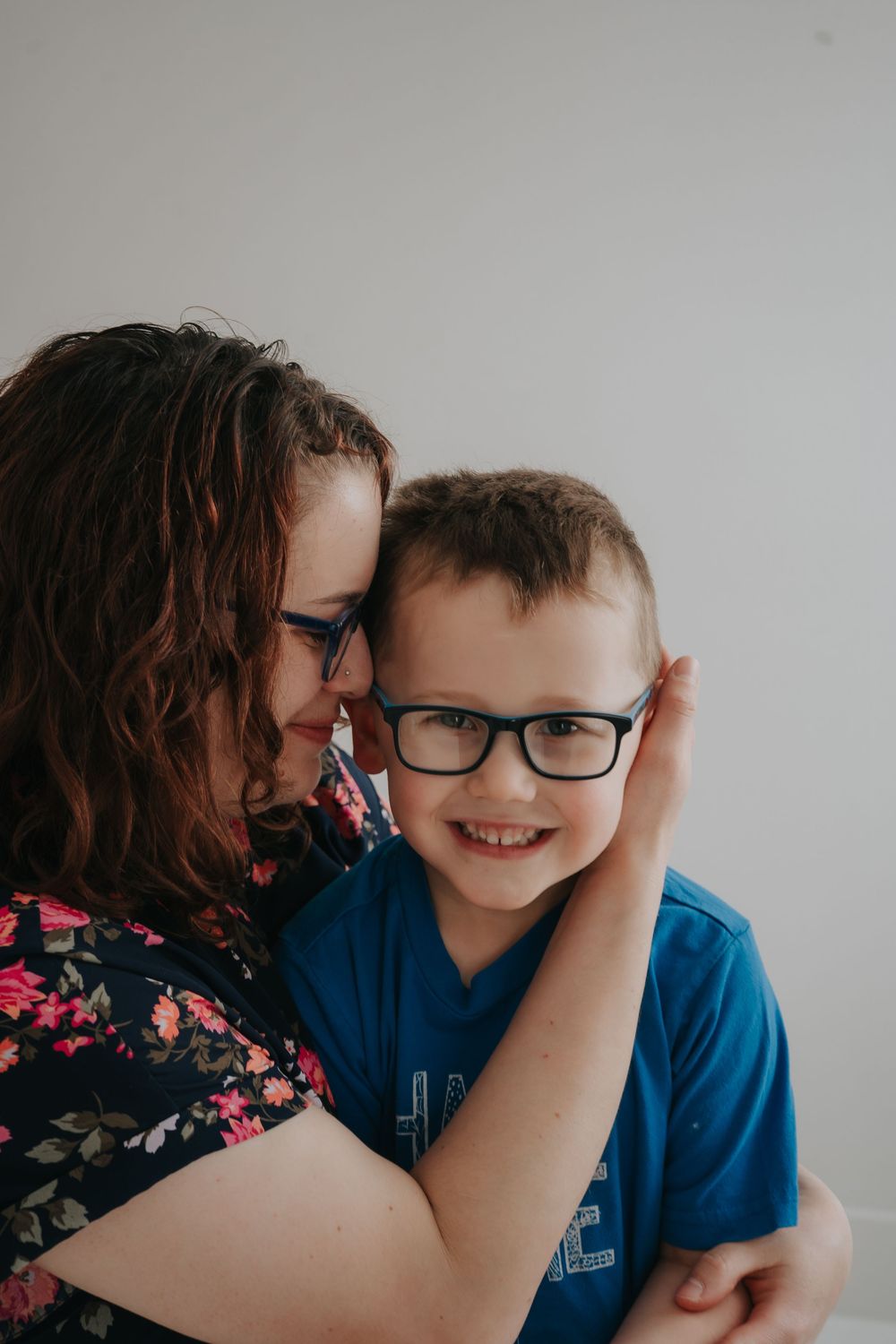 A tender family portrait showing affection and joy against a light background.
