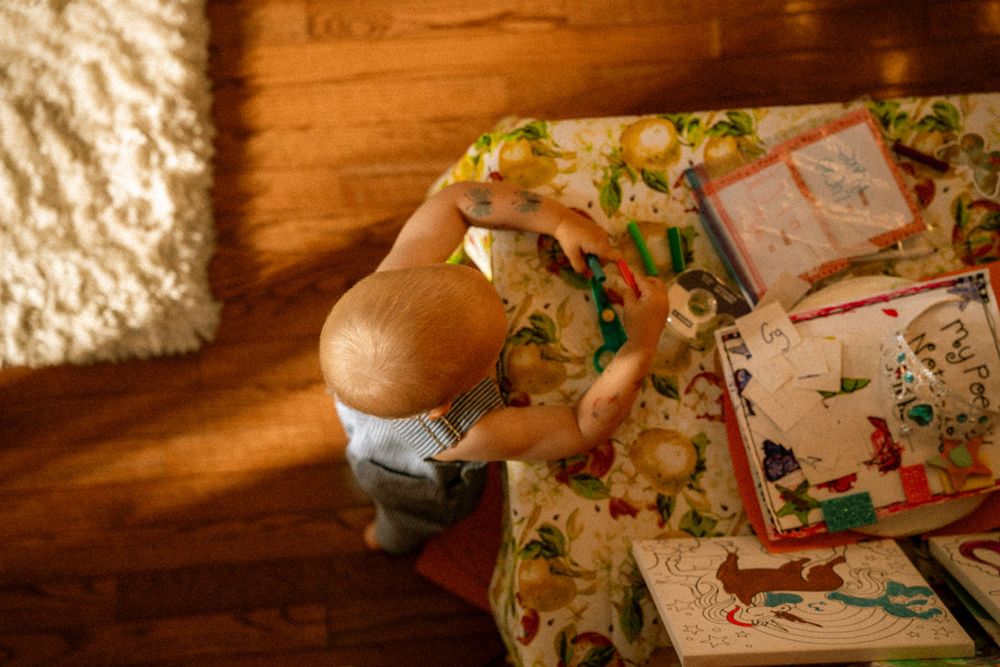 Overhead view of someone reading a storybook on a wooden floor.