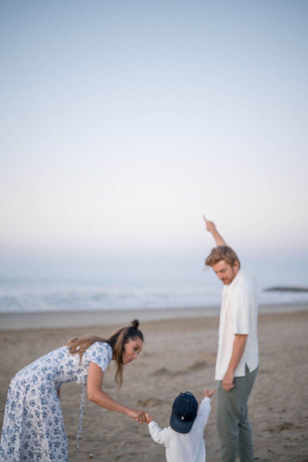 A tender moment captured on a beach at sunset with a small child.