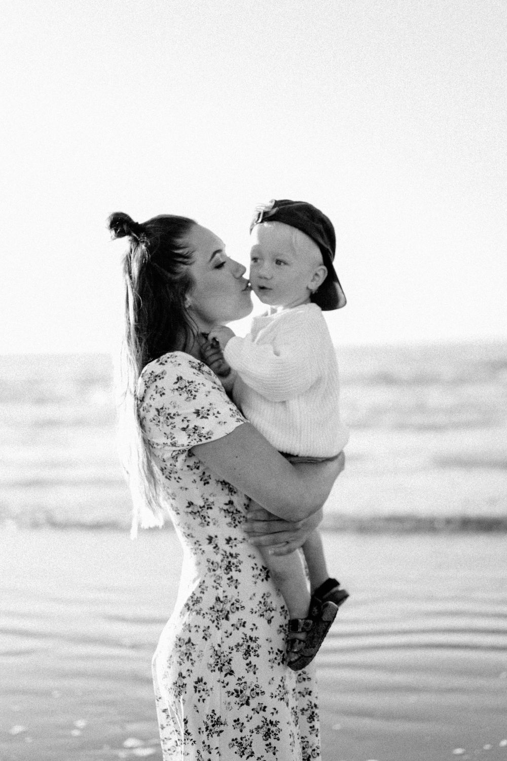 A tender moment at the beach captured in black and white.