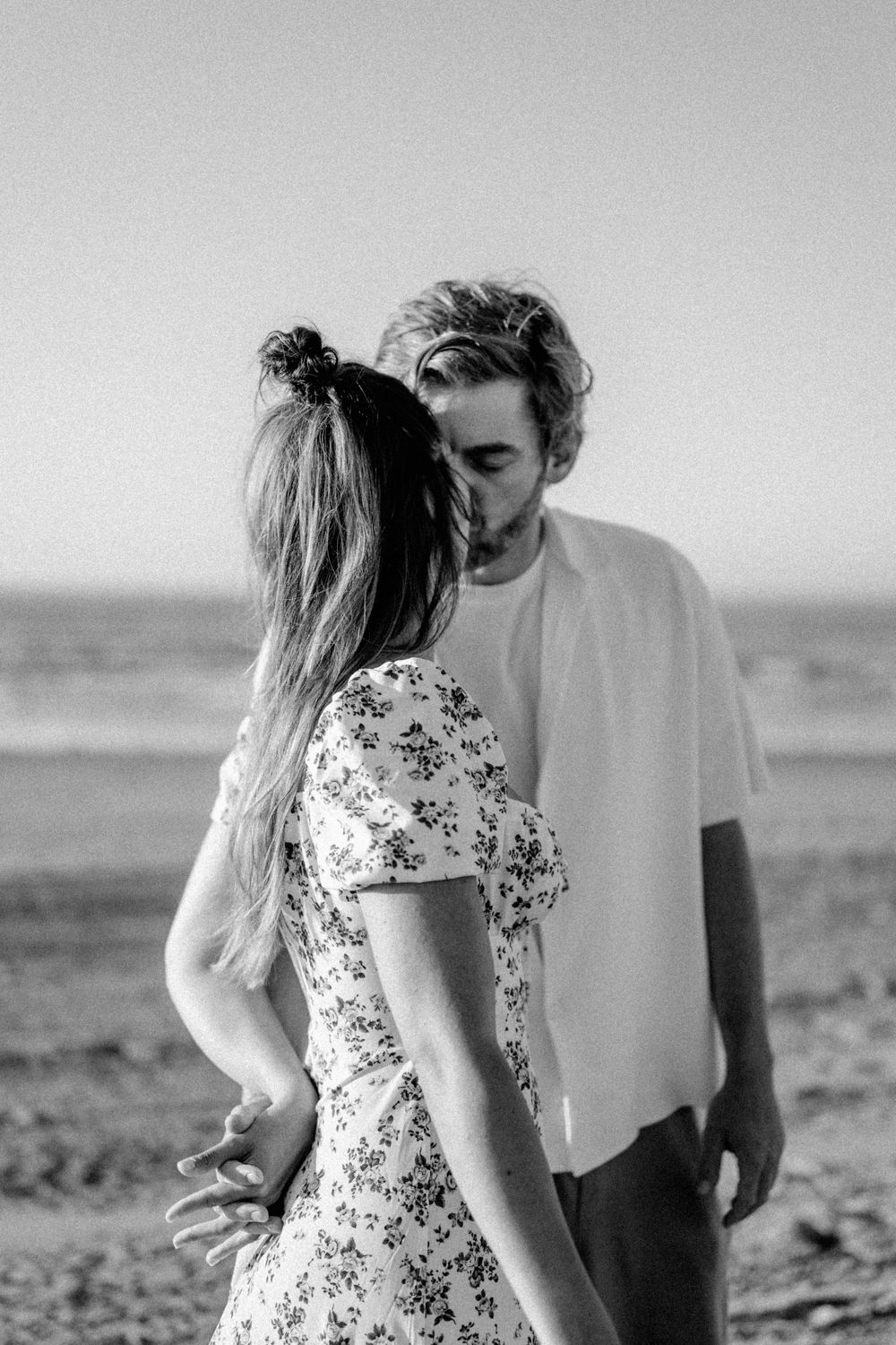An intimate black and white portrait on the beach.
