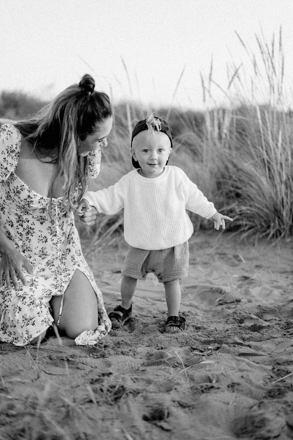 A joyful moment shared on sandy dunes in black and white.