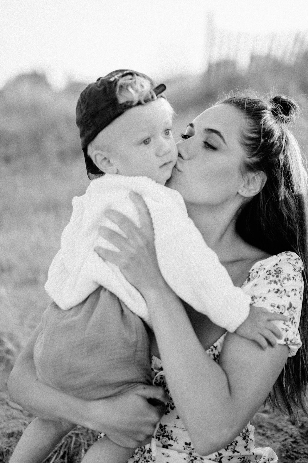 Black and white portrait capturing an intimate family moment outdoors.